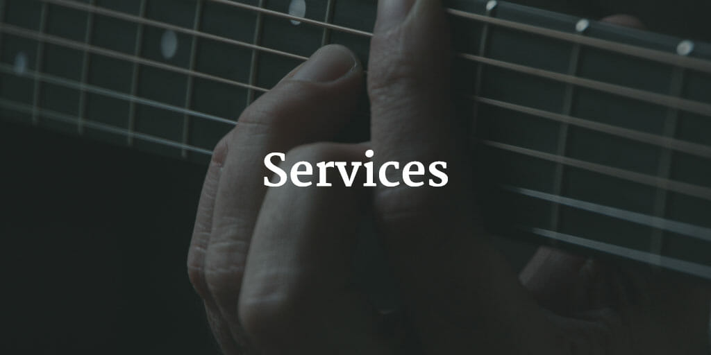 A photo of a hand playing a guitar with the text "Services" super-imposed over it.