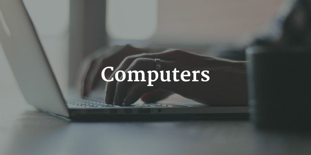 A photo of hands typing on a computer with the text "Computers" super-imposed over it.