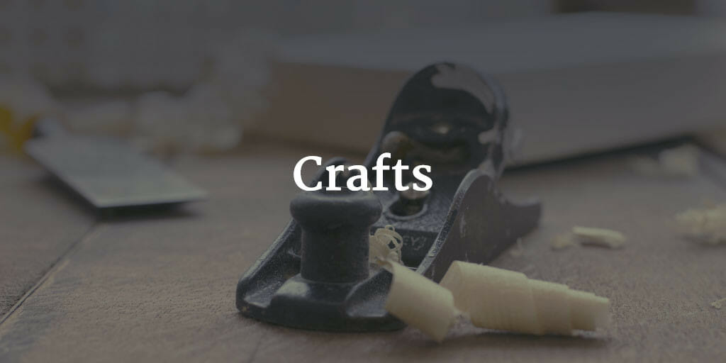 A photo of a wood plane shaving a board with the text "crafts" super-imposed over it.